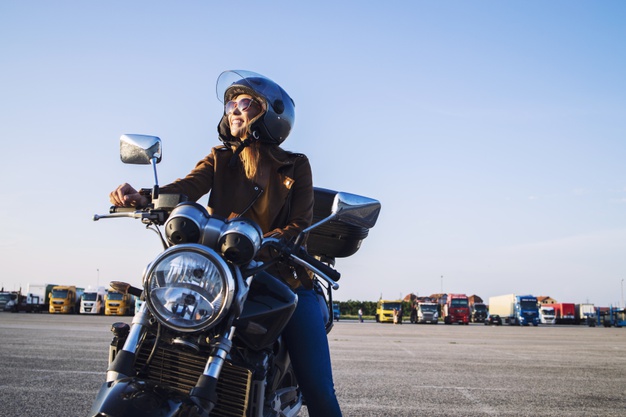 Jeune fille blonde sur une moto avec casque noir